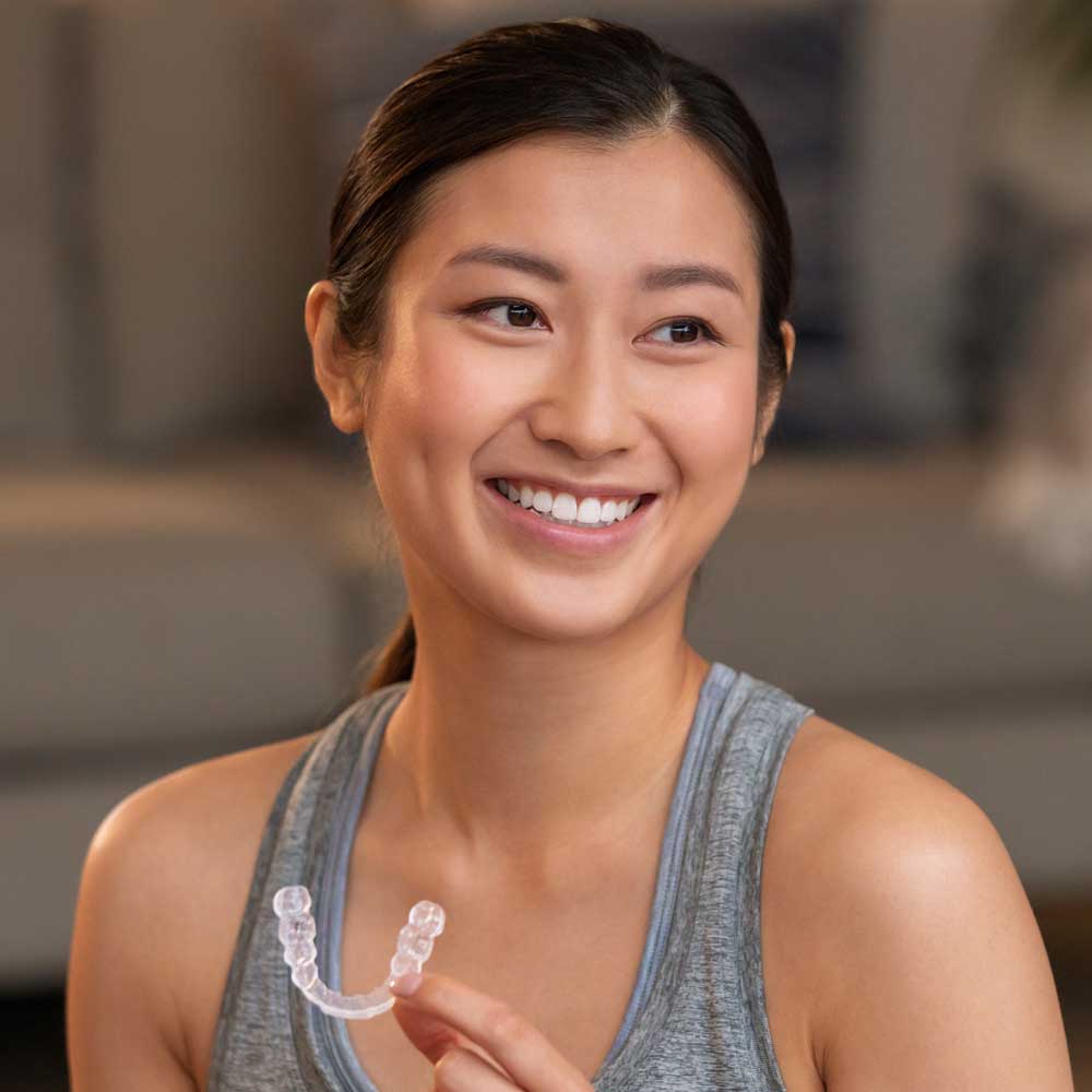Lady holding an Invisalign aligner